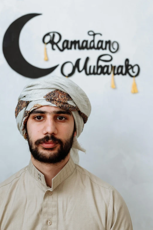 a man with a turban standing in front of a wall, inspired by Osman Hamdi Bey, pexels contest winner, hurufiyya, moon behind him, wearing festive clothing, 2 3 years old, halfbody headshot