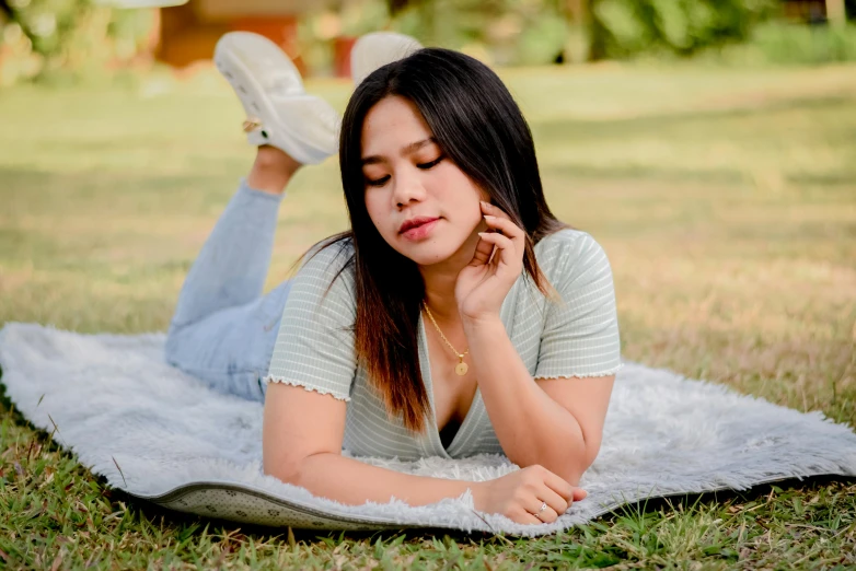 a woman laying on the grass in a park