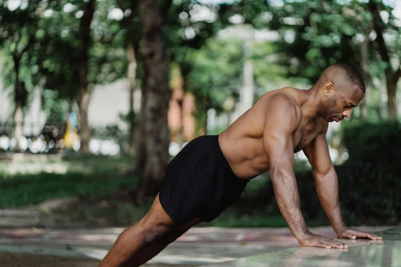 a shirtless man doing a push up on a skateboard, pexels contest winner, renaissance, background image, black man, swollen muscles, nature outside