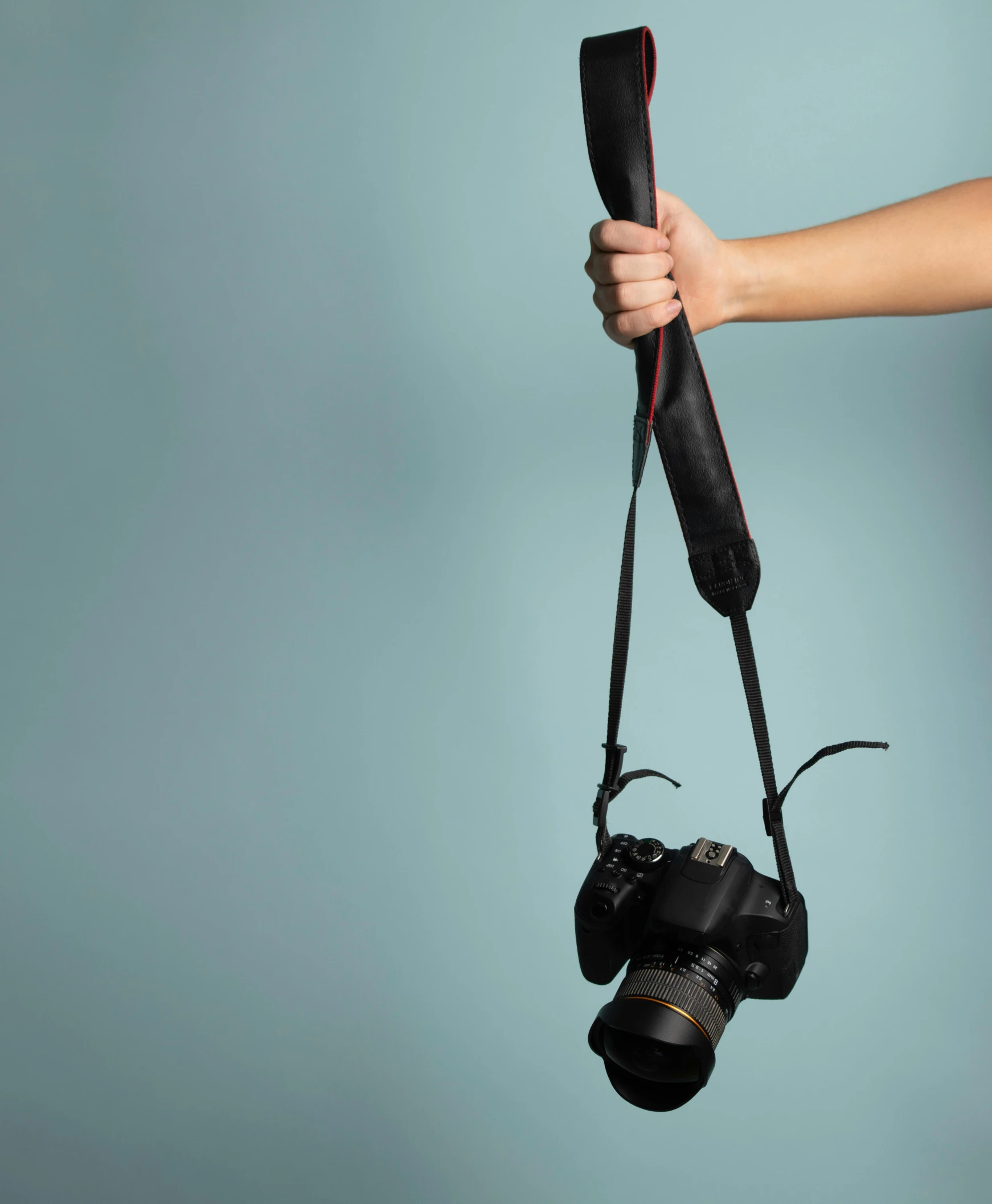 a person holding a camera in their hand, bra strap, black canvas, posed, colour photograph