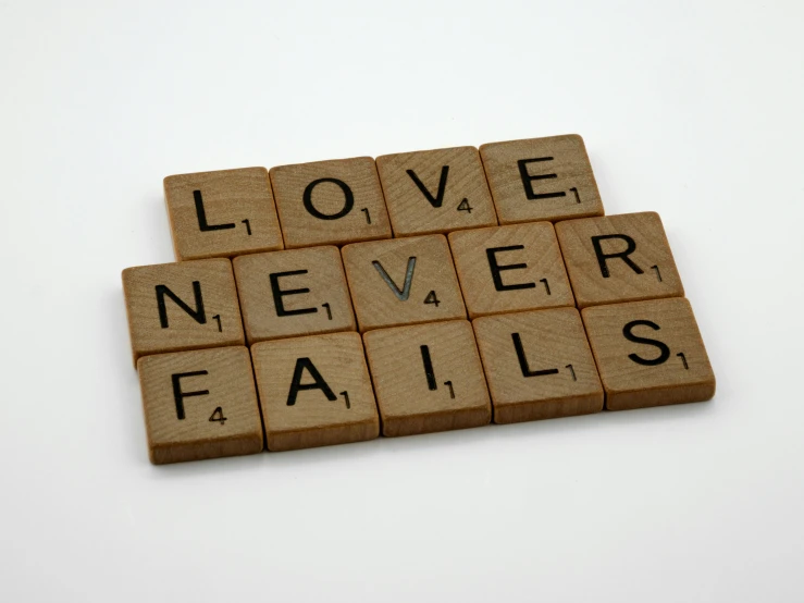 a scrabble that says love never fails, unsplash, squares, biblically accurate, wood print, thumbnail