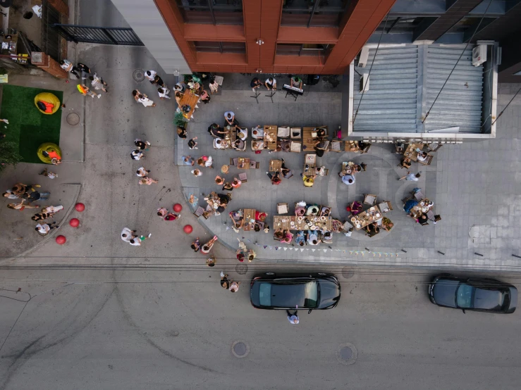 people sitting at outdoor tables next to tall buildings