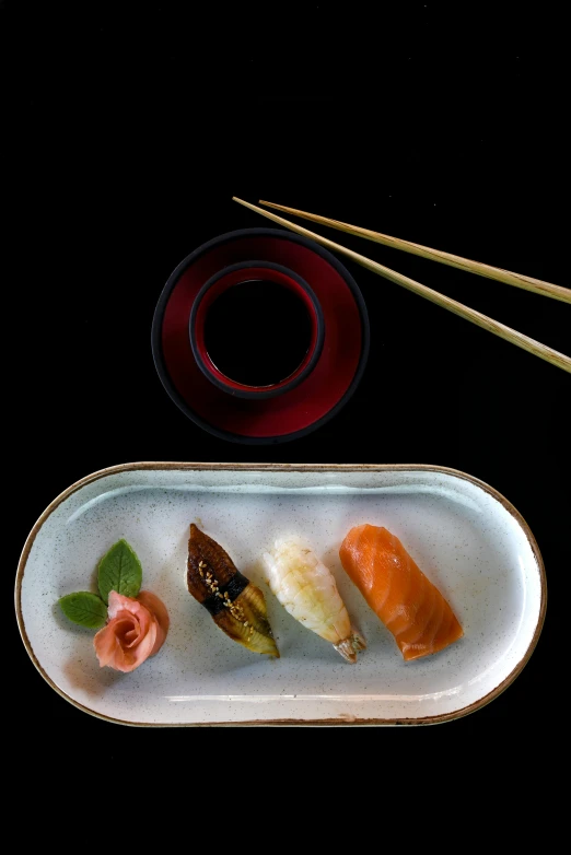 a plate of sushi and chopsticks on a table, a still life, inspired by Kanō Shōsenin, plating, black, terada katsuya, brown