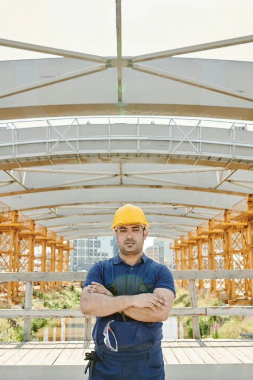 a construction worker standing with his arms crossed, pexels contest winner, renaissance, rounded roof, steel archways, portrait image, commercial banner