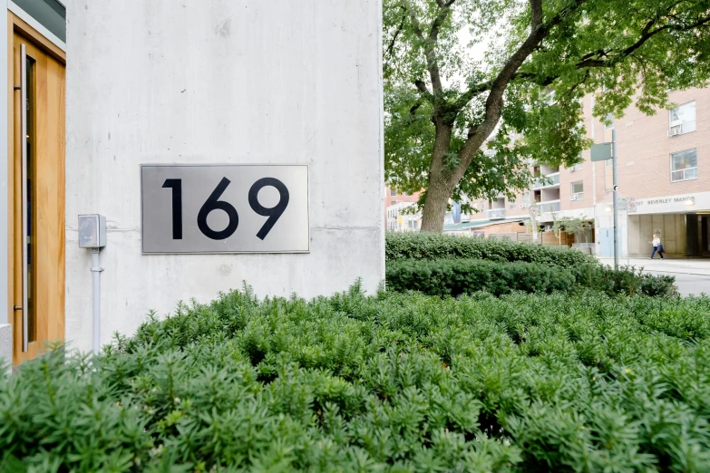 a house number sign on the side of a building, by Washington Allston, unsplash, bauhaus, grassy knoll, stainless steal, 15081959 21121991 01012000 4k, north melbourne street