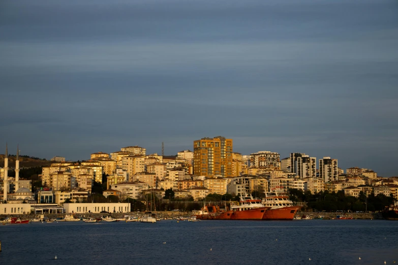 a large body of water with a city in the background, by Doug Ohlson, pexels contest winner, hurufiyya, late afternoon light, stacked image, seaside, split near the left