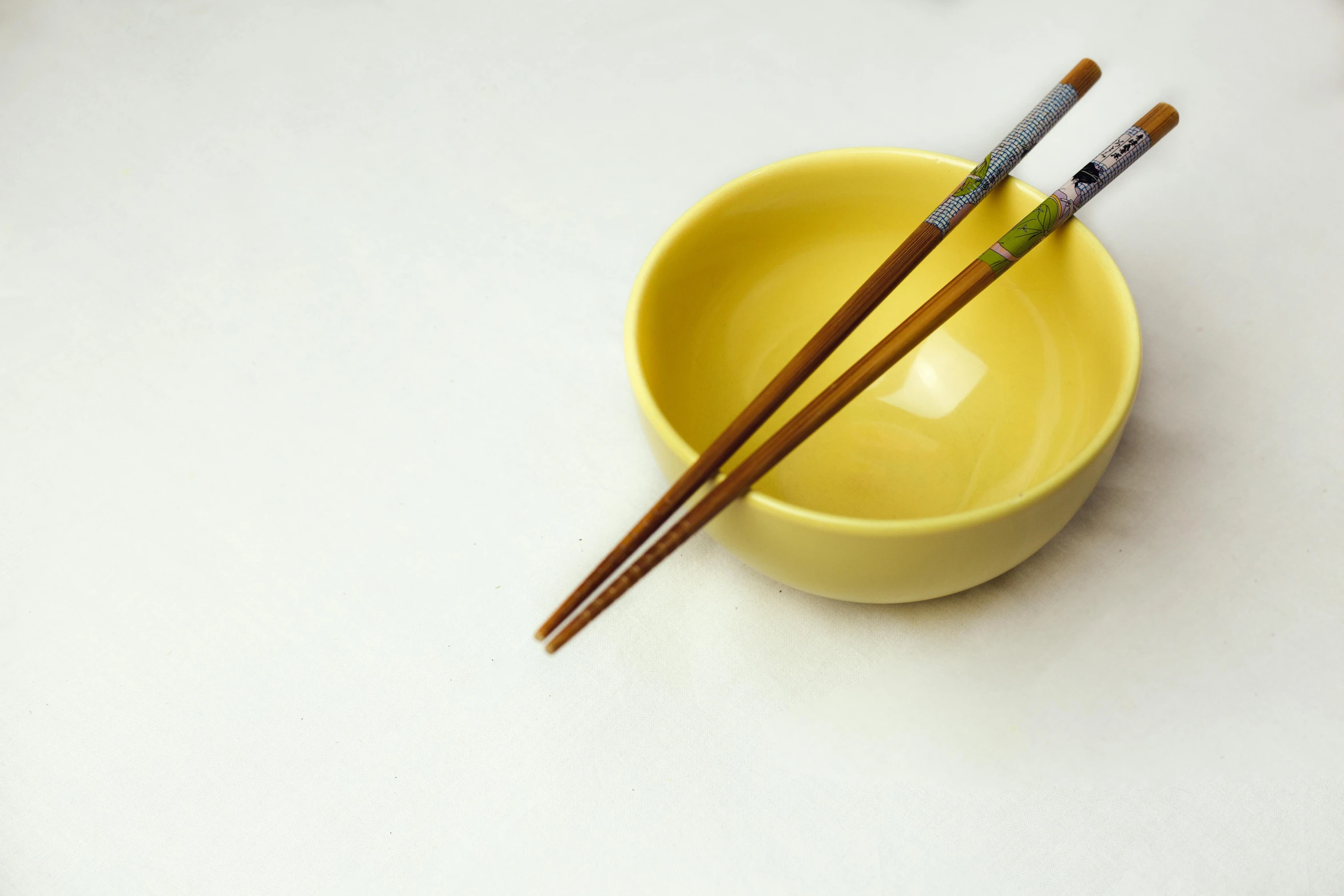 a yellow bowl with two chopsticks in it, a photorealistic painting, unsplash, white, handcrafted, fork, highly realistic photo