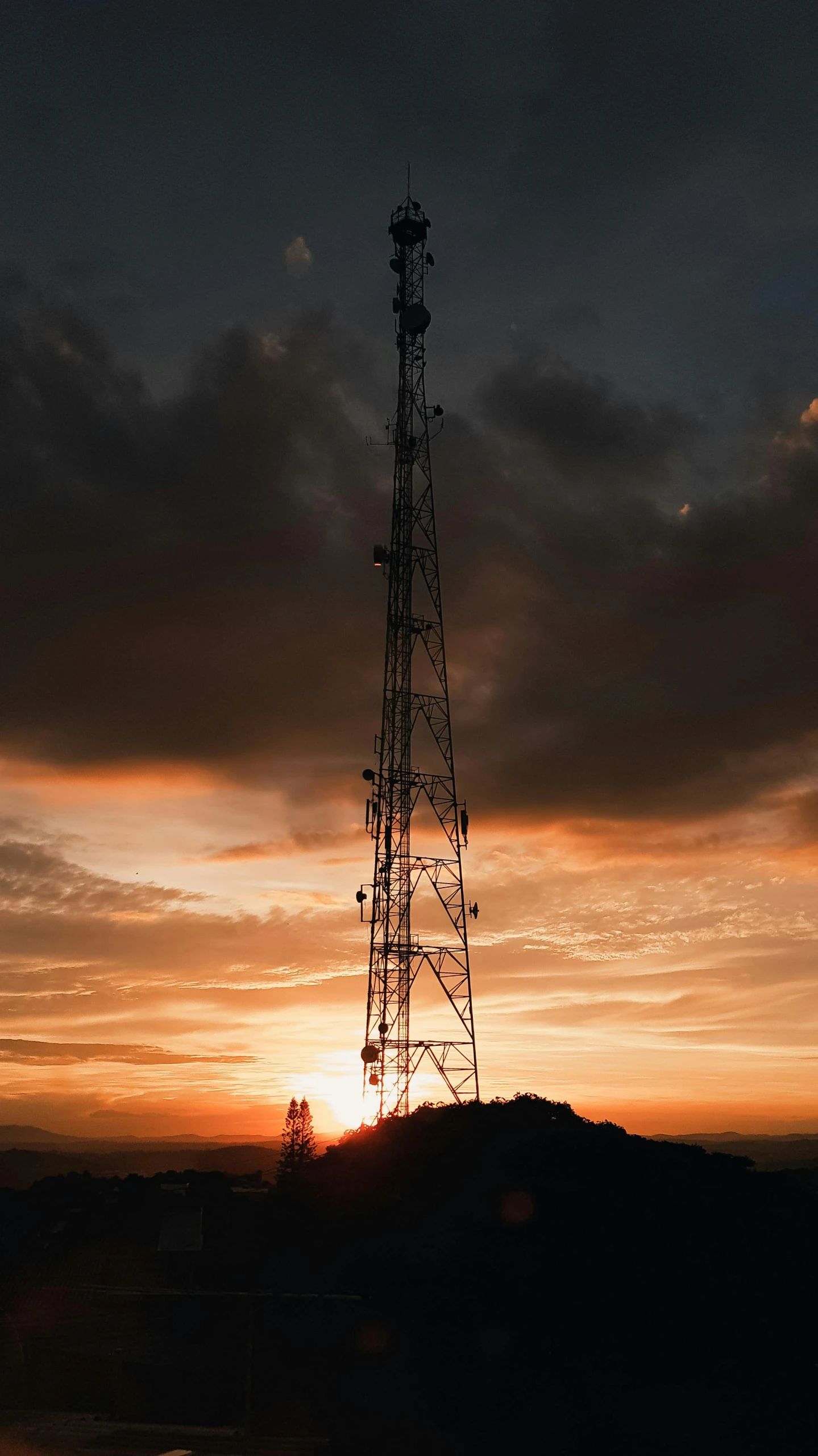 the sun is setting behind a radio tower, by Adam Marczyński, unsplash contest winner, renaissance, on black background, on the top of a hill, cellular, a handsome