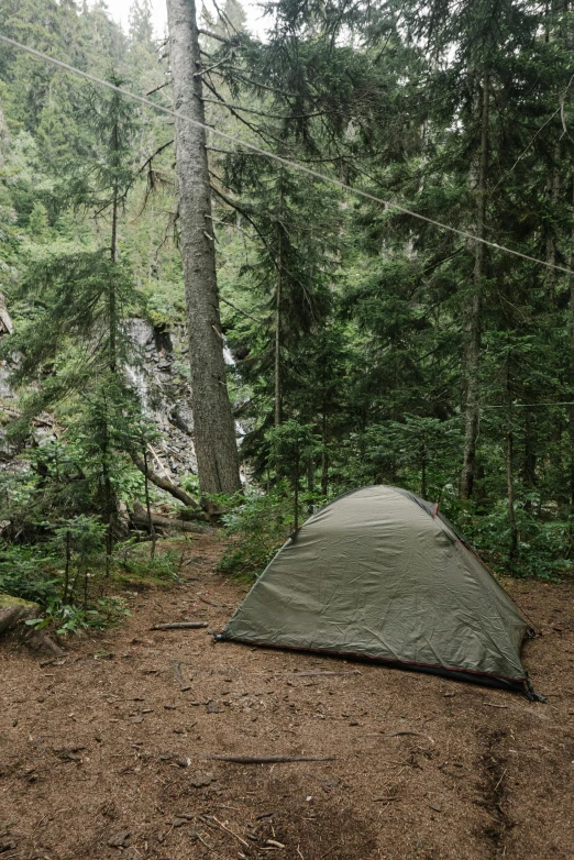 a tent pitched up in the middle of a forest, minn, next to a waterfall, ƒ/5.6, slide show