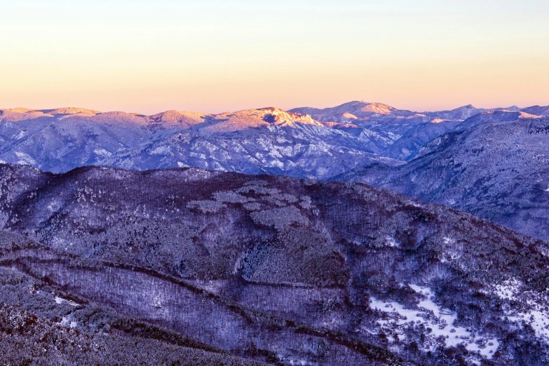 the sun is just going down on some mountains