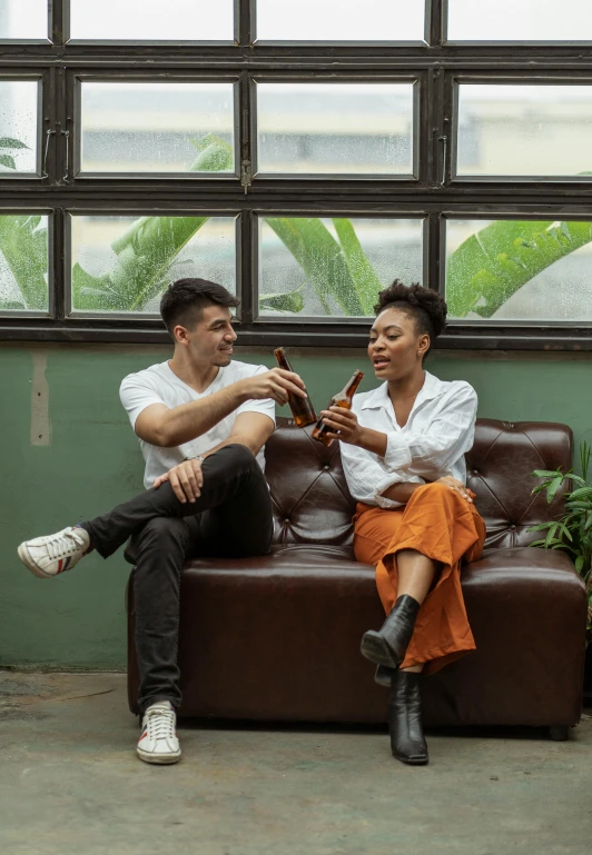 a couple of people that are sitting on a couch, by Adam Marczyński, pexels contest winner, holding a bottle, sao paulo, ashteroth, promotional image