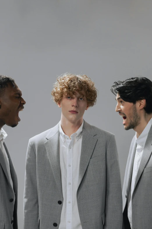 a group of men standing next to each other, an album cover, trending on pexels, yawning, grey suit, bo burnham, apprehensive mood