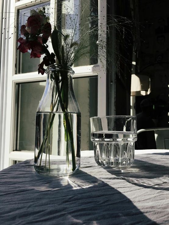 two vases with flowers sitting on a table