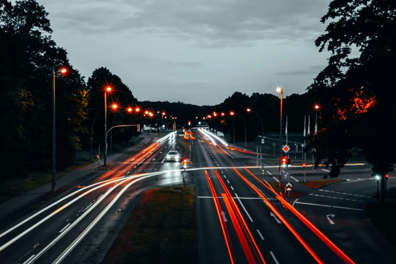 a city street filled with lots of traffic at night, by Adam Marczyński, pexels contest winner, realism, speed lines, thumbnail, highway, city lights made of lush trees