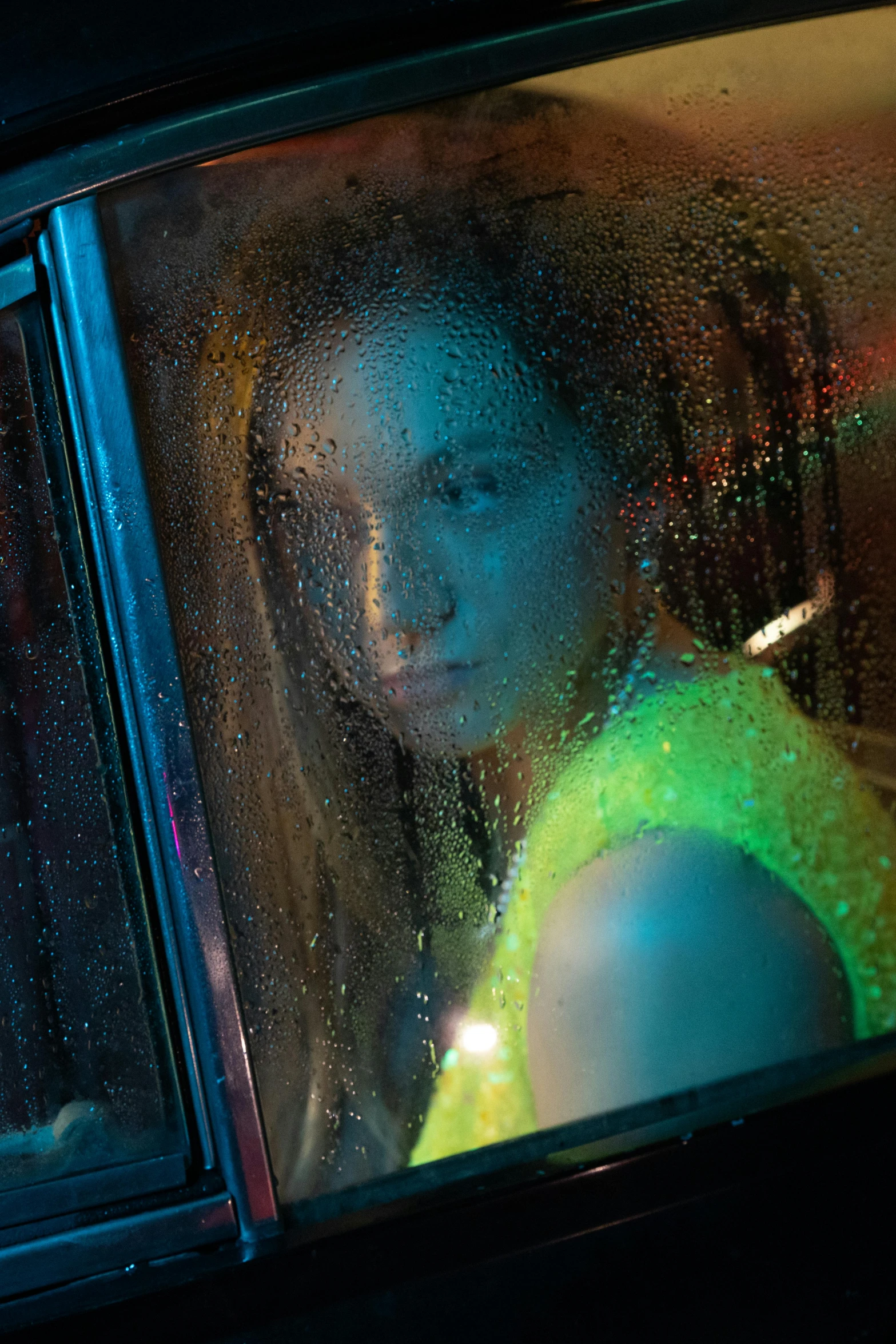 woman looking out window at rain drops outside