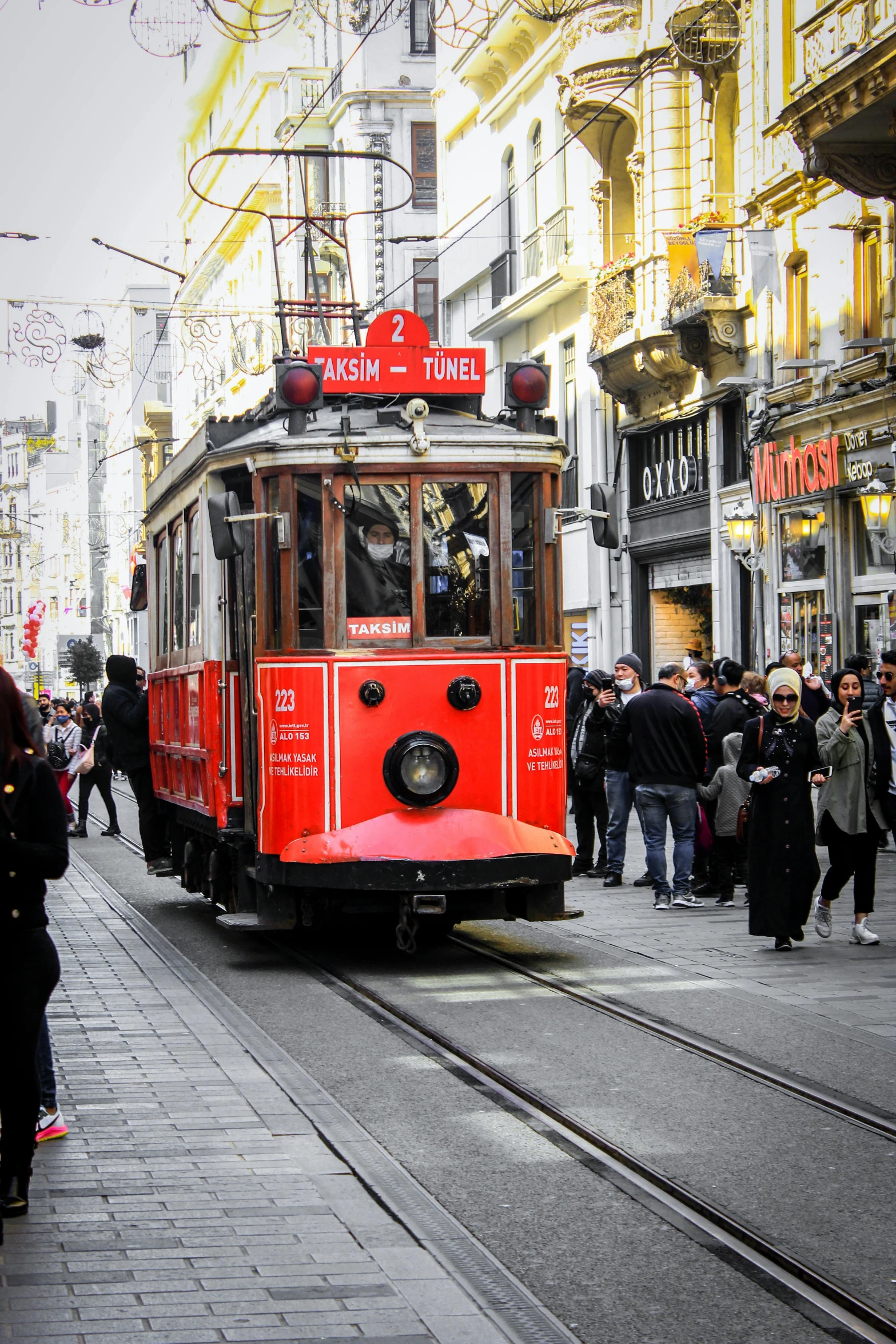 a red trolly car traveling down a city street