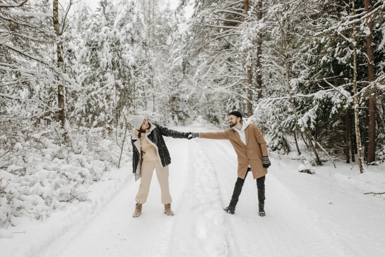 two people holding hands in the middle of the snow