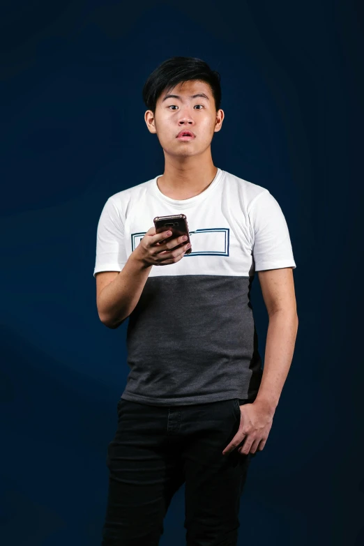 an asian man is holding a cell phone