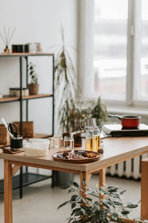 a wooden table topped with drinks next to shelves of pots