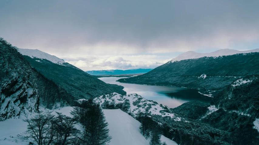 the view from the top of a mountain looking down on a snowy valley