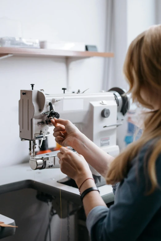 a woman is sewing on the machine