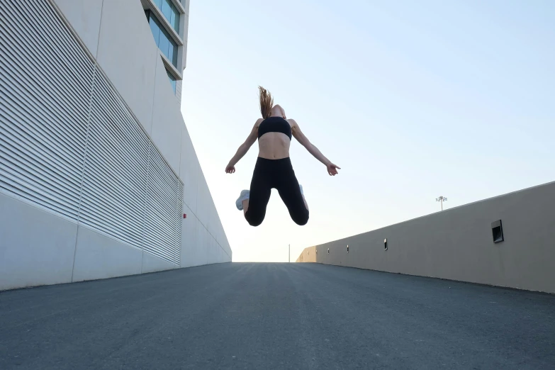 a woman flying through the air while riding a skateboard, by Carey Morris, pexels contest winner, arabesque, wearing a black cropped tank top, on a rooftop, running pose, snapchat photo
