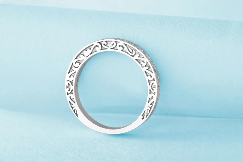 a close up of a ring on a blue surface, arabesque, platinum jewellery, white frame border, titanium white, monochrome