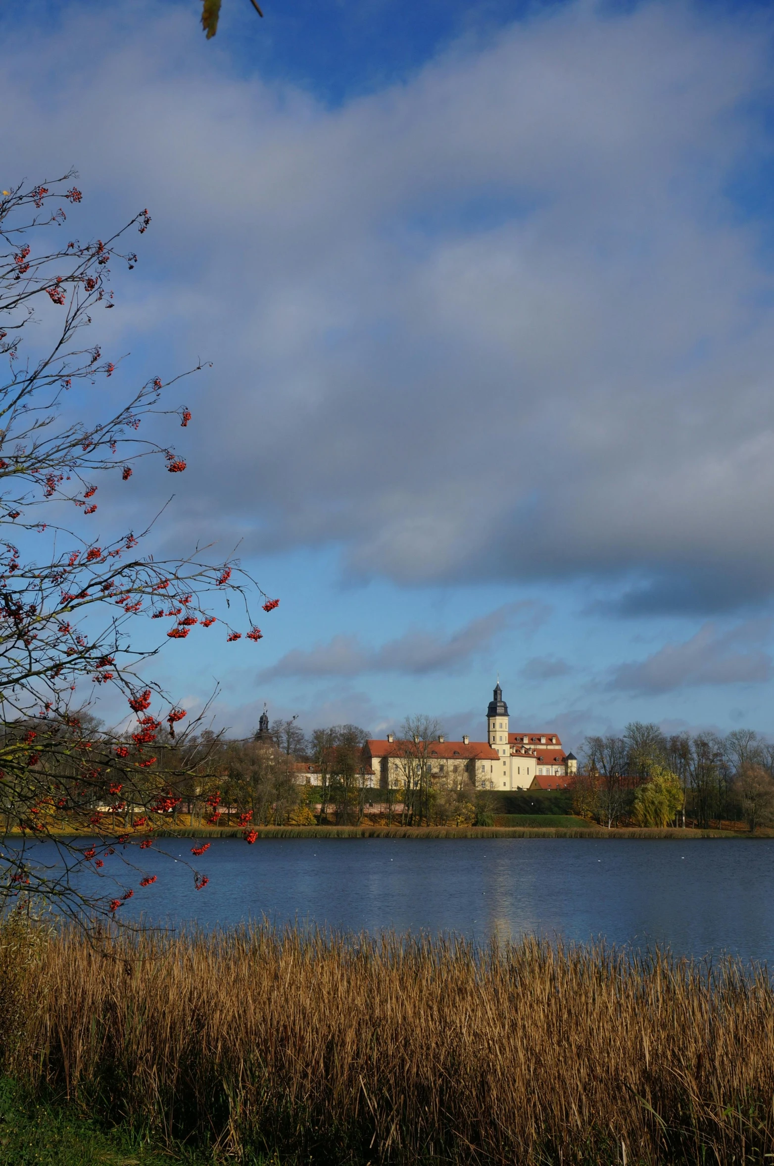 a large body of water with a building in the background, a picture, inspired by Lars Jonson Haukaness, flickr, during autumn, red castle in background, today\'s featured photograph 4k, college