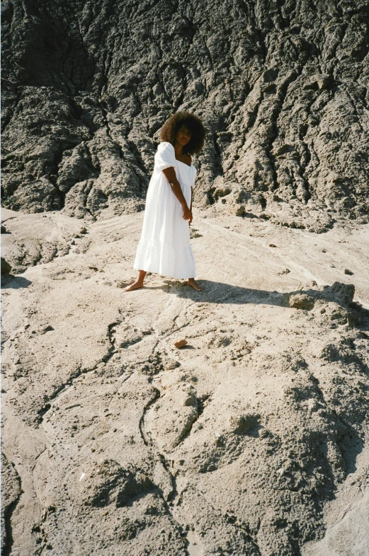  in white dress standing in rock formation