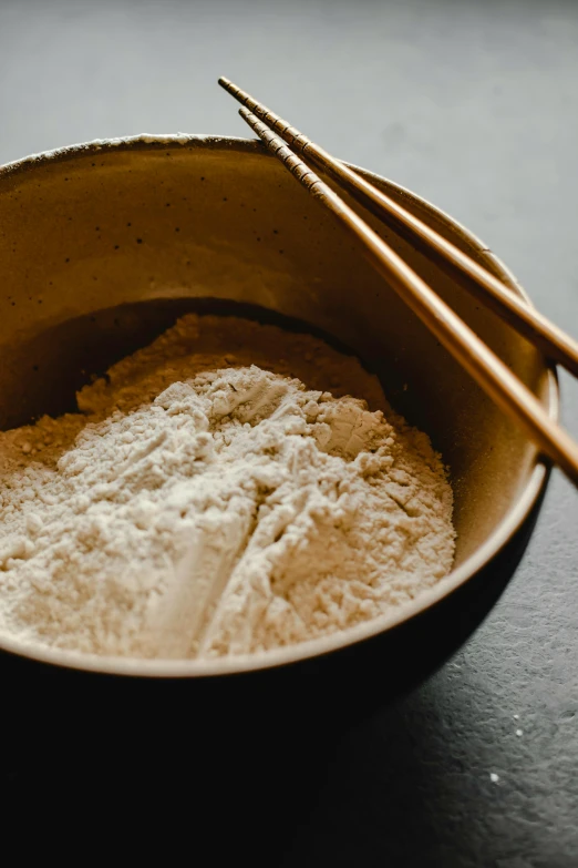 a close up of a bowl of food with chopsticks, a portrait, unsplash, process art, flour dust, bakery, grey, blue