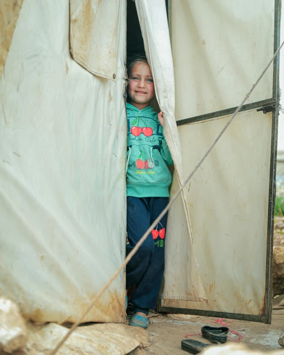 a little girl standing in the doorway of a tent, by Arabella Rankin, hurufiyya, refugees, high quality photo, square, jen atkin