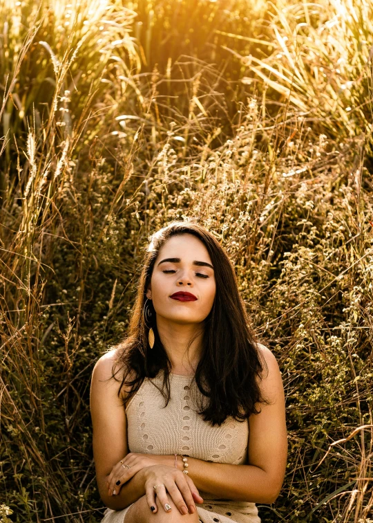 a woman sitting in a field of tall grass, inspired by Elsa Bleda, trending on pexels, relaxed. gold background, headshot profile picture, avatar image, high quality picture