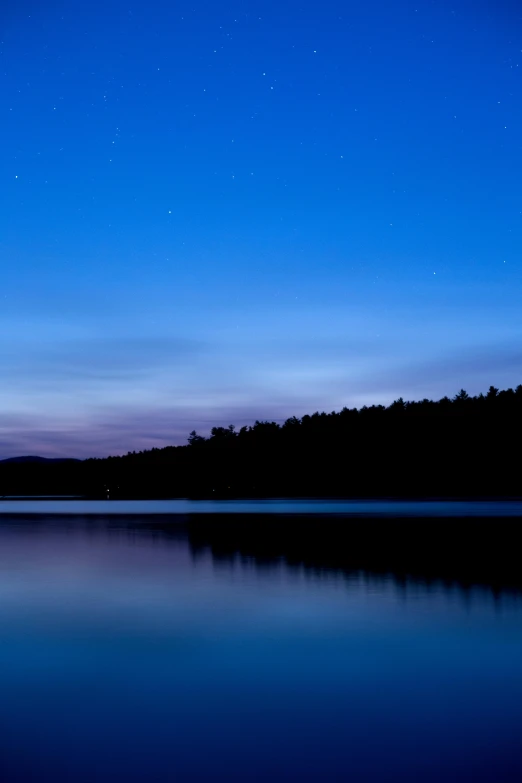 a large body of water next to a forest, by Doug Ohlson, minimalism, blue hour stars, new hampshire, full frame image, today\'s featured photograph 4k