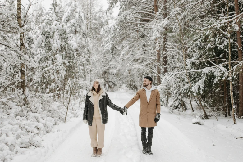 two people are holding hands in the snow