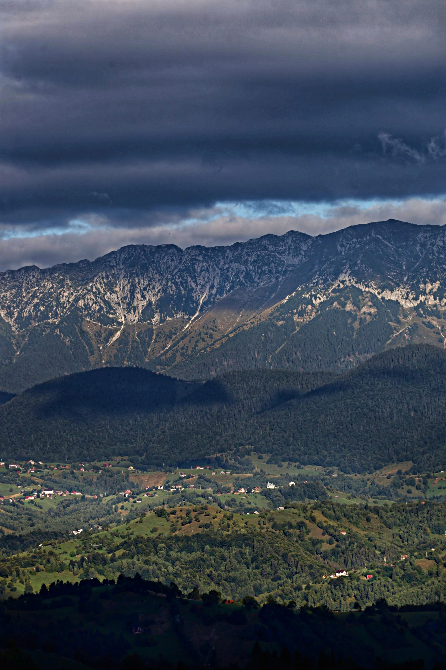 a distant s of a mountain range, with the sky almost dark and stormy