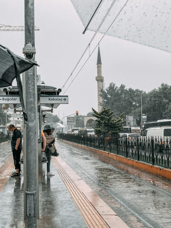 a couple of people that are standing under an umbrella, by irakli nadar, pexels contest winner, hurufiyya, train station in summer, wet sidewalk, mixture turkish and russian, 🚿🗝📝