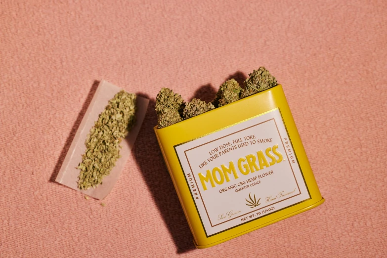 a box of marijuana sitting on top of a pink surface, mom, the grass, detailed product image, the madness of mono-yellow