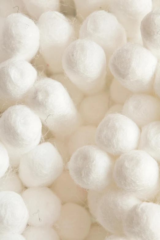 a pile of white cotton balls sitting on top of a table, white mechanical details, zoomed in, felt, white: 0.5