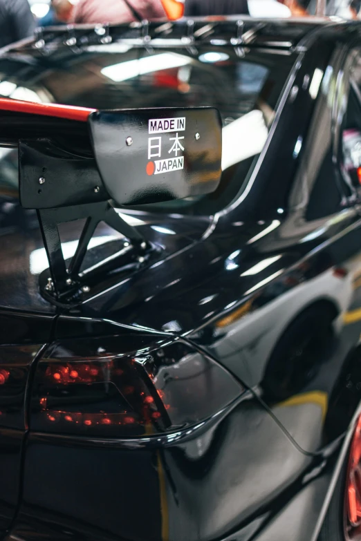 back end of a japanese black car with an asian character on it