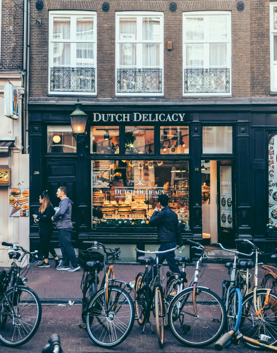 bicycles are parked outside of a dutch delikacy shop