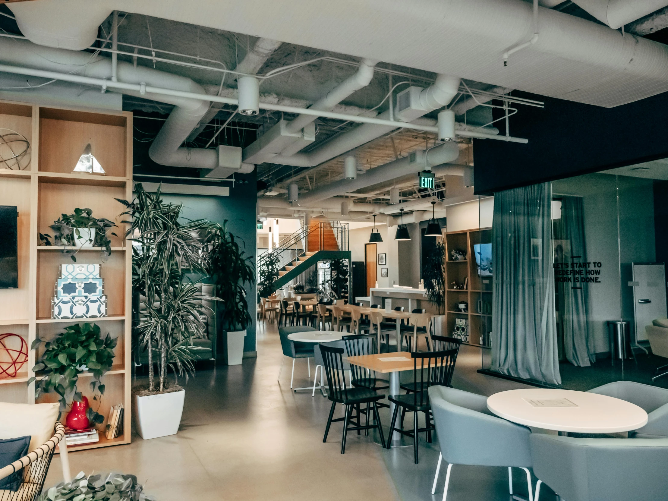 an office space with multiple tables and chairs