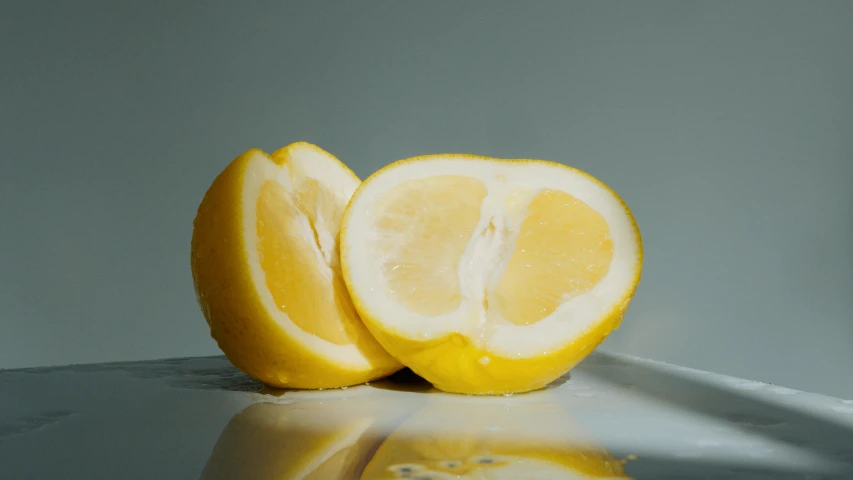 a couple of lemons sitting on top of a table, shiny crisp finish, split in half, lumi, detailed product image