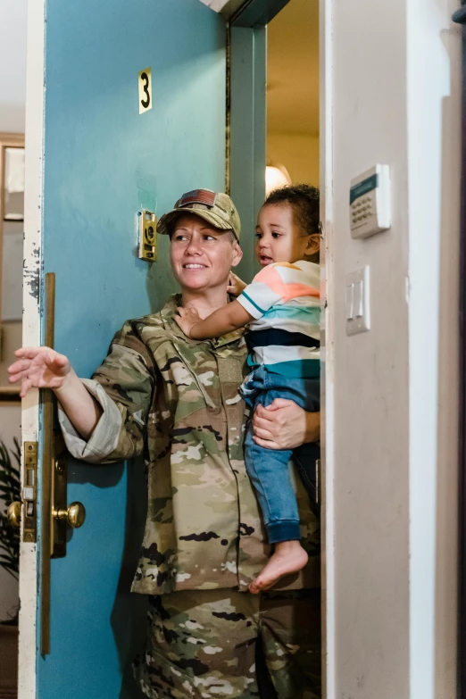 a soldier is holding a child in his arms, by Kristin Nelson, about to enter doorframe, slide show, square, high quality photo