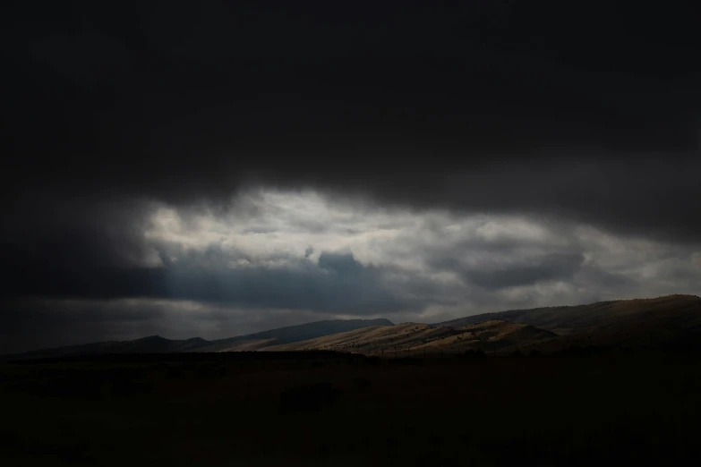 a distant mountain range with storm clouds in the background