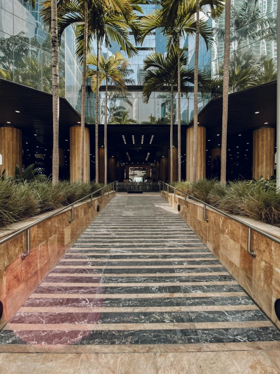 an open air atrium with marble steps and palm trees