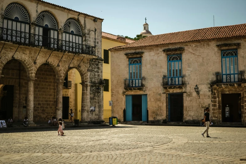 two people walking through a courtyard in an old building