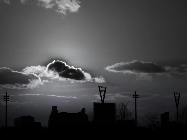 a black and white photo of a cloud in the sky, a black and white photo, inspired by Brassaï, deviantart, city sunset night, artistic!!! composition, suns, neon signs in the distance