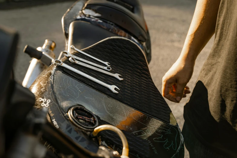 a man holding the seat of a black motorcycle