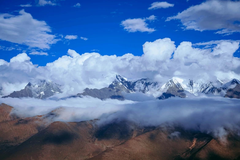 a mountain range with low clouds in the sky