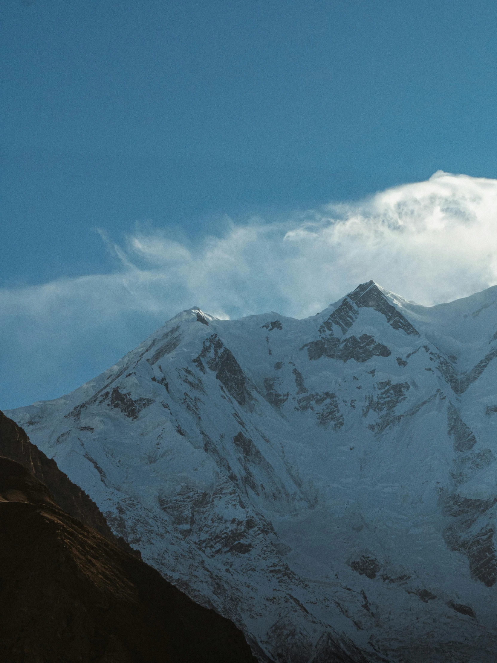 snow covered mountains against a deep blue sky